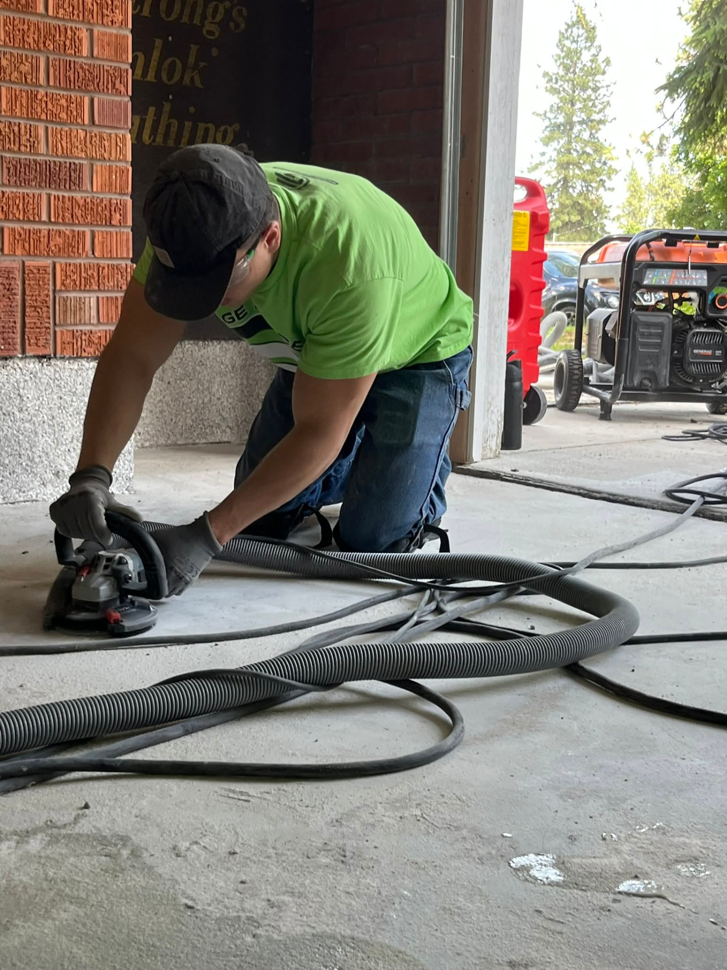 Installer grinding concrete before coating